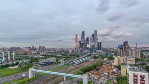 高層ビルのビジネス複合体モスクワ市の航空パノラマの日から夜への移行時間経過 前景では 鉄道と自動車の陸橋 屋上から日没後の曇りの空と交通 — ストック動画