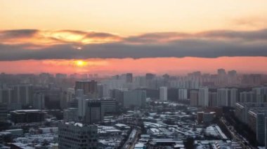 Yukarıdan Moskova 'ya. Rusya 'da kış akşamı karla kaplı binaların üzerinde bulutlarla gün batımı panoramik hava manzaralı zaman dilimi