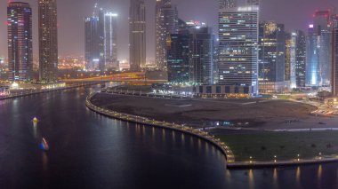 Cityscape of skyscrapers in Dubai Business Bay with water canal aerial day to night transition . Modern skyline with towers and waterfront after sunset. A center of international business