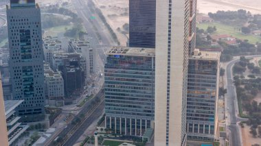 Office skyscrapers with illumination in financial district aerial night to day transition . Top view to hotels and traffic on a road from above before sunrise