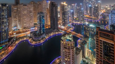 Dubai Marina ve JBR bölgesindeki çeşitli gökdelenlerin görüntüsü suni kanalla gündüz-gece geçişi. Gün batımından sonra birçok kule ve yat