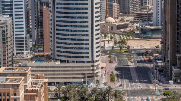 巴沙高地区的摩天大楼和清真寺 格林斯区的低层建筑 阴影快速移动 迪拜的天际线 有棕榈和树木环绕交叉口 — 图库照片