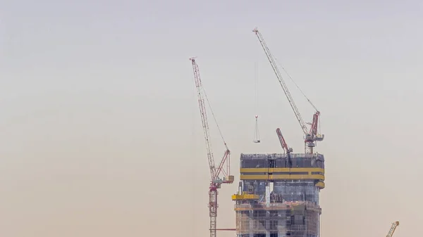 新しい超高層ビルの建設現場で働くクレーン 都市開発の迅速な成果と進展の構築 — ストック写真