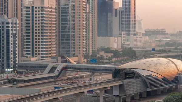 迪拜地铁站的未来派建筑和迪拜码头的豪华摩天大楼在日出前一天到晚的过渡 阿拉伯联合酋长国谢赫扎耶德公路的交通情况 — 图库照片