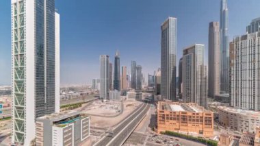 Dubai şehir merkezinin gökyüzü görüntüsü, bir çok kulenin zaman çizelgesi var. Kavşakta üst geçitle yoğun bir trafik var. İş alanında hareket eden gölgeler. Gökdelen ve yüksek binalar yukarıdan, BAE.