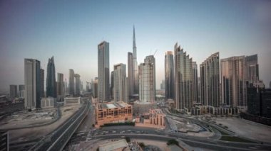 Dubai şehir merkezinin panoramik hava görüntüsü. Günbekten geceye geçiş zamanına kadar pek çok kule var. İş alanı yoğun yol trafiği. Günbatımından sonra gökdelen ve yüksek binalar, BAE