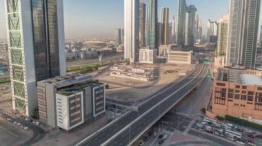 Dubai şehir merkezi ve finans bölgesinde caddelerde trafiği olan fütürist kuleler ve gökdelenler. Kentsel Ufuk Çizgisi hava zaman çizelgesi. Arka planda şehir yürüyüşü