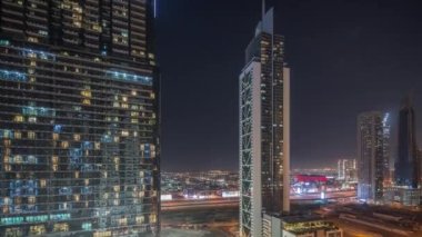 Dubai şehir merkezi ve finans bölgesinde Şeyh zayed yolunda trafik olan fütüristik kuleler ve aydınlık gökdelenler. Parlak pencereler. Kentsel şehir gökyüzü çizgisi gece zaman çizelgesi.