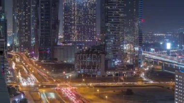 Modern mimari zaman çizelgesi olan Business Bay bölgesi ufuk çizgisi. Yol ayrımında trafik vardı. Dubai gökdelenlerinin ve ana karayolu yakınlarındaki aydınlık kulelerin havadan görüntüsü.