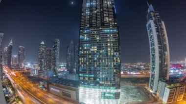 Modern mimari zaman çizelgesiyle gökyüzüne yükselen Business Bay District Panorama. Dubai gökdelenleri ve ana karayolu yakınlarındaki aydınlık kulelerin havadan görüntüsü. Kavşakta trafik vardı.