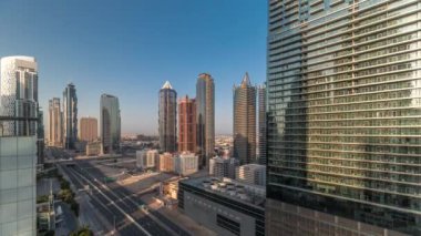 Business Bay semtinin ufuk çizgisi modern mimari ile sabah saatleri yukarıdan geliyor. Güneş doğarken, ana karayolu yakınlarındaki Dubai gökdelenleri ve kulelerinin hava manzarası. Uzun gölgeler hızlı ilerliyor