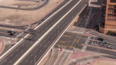 Yoğun yol kesişiminin ve Dubai 'deki trafik kavşaklarının üst hava görüntüsü. Trafik sıkışıklığından kaçınmak için kavşak ve otoyolların modern inşaat tasarımı. Sürücü arabaları
