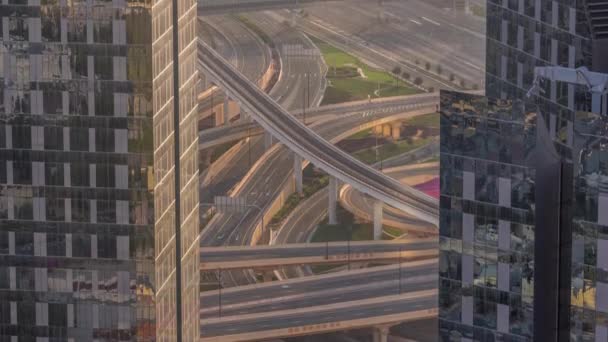在日落的时候 迪拜市中心摩天大楼与一个巨大的繁忙的公路交叉口之间的空中景观与地铁线之间的时间间隔了很久 汽车和卡车沿着大路直向两边行驶 — 图库视频影像