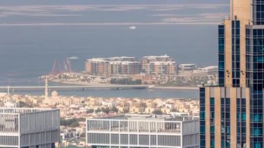 Şehir merkezindeki Dubai şehrindeki apartman ve villaların hava manzarası. Camili gökdelenin arkasına bak. Arka planda yapay adalar. Birleşik Arap Emirlikleri