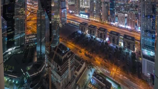 迪拜谢赫扎耶德路上的高层建筑 空中夜间全景时间经过 阿联酋 从上方看国际金融区的摩天大楼 城市背景下的步行房屋和别墅 — 图库视频影像