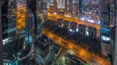 Dubai 'deki Sheikh Zayed Yolu' ndaki yüksek binalar gece gündüz panoramik zaman geçişi, BAE. Finans bölgesindeki gökdelenler. Arka planda evler ve villalar var.