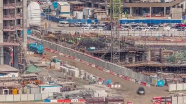 Çalışan vinçleri olan büyük bir inşaat alanı. Takviye yapan işçiler. Business Bay, Dubai 'deki büyük yerleşim ve ofis alanının en iyi hava manzarası