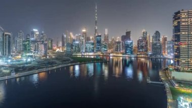 Dubai Business Bay ve şehir merkezinin havadan görüntüsü. Kanal boyunca çeşitli gökdelenler ve kuleler var. Vinçli inşaat alanı