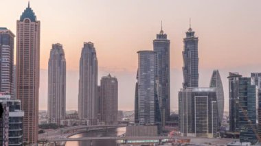 Dubai İşletme Koyu 'nun gökdelenleri ve su kanalı havadan akşama geçiş zamanı olan şehir manzarası. Günbatımından sonra rıhtımda konut ve ofis kuleleri olan modern gökyüzü