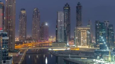 Dubai İşletme Koyu 'nun gökdelenleri ve su kanalı antenleri olan şehir manzarası. Gece gündüz geçiş zamanı. Gündoğumundan önce rıhtımda konut ve ofis kuleleri olan modern gökyüzü.