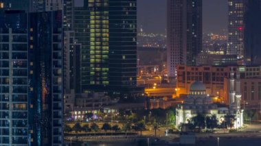 Bay Bulvarı yakınlarındaki yeni beyaz cami. Alışveriş merkezi Business Bay hava sahasında gökdelenlerle çevrili. Gün doğumundan önce geçiş zamanı. Otoparkın yanındaki yolda trafik vardı.