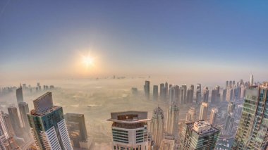 Dubai Marina Panoraması, güneş doğarken JLT gökdelenleri ve golf sahası, Dubai, Birleşik Arap Emirlikleri. Yukarıdan hava manzarası sisli bir sabah. Çatıları olan şehir silüeti