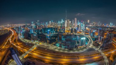 Dubai 'nin panoramik silueti, iş sahası ve şehir merkezi ile gece gündüz. Günbatımından sonra Al Khail yolunda trafiği olan birçok modern gökdelenin geniş açılı görüntüsü.