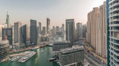 Panorama showing overview to JBR and Dubai Marina skyline with modern high rise skyscrapers waterfront living apartments aerial. Yachts floating on water of canal. JLT district on a background