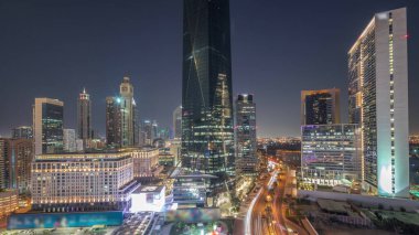 Dubai Uluslararası Finans Bölgesi, günden geceye geçiş. Gün batımından sonra panoramik ofis kulesi manzarası. Şehir merkezine yakın otelleri ve alışveriş merkezleri olan gökdelenler.