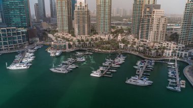 Lüks tekne ve yatlar bütün gün boyunca Dubai Marina 'da gölgelerin hızla ilerlediği limana yanaştı. Rıhtımda limana yakın park etmiş motorlu tekneler.