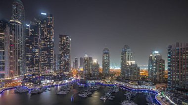Panorama, liman gecesinde Dubai marinasının en yüksek gökdelenlerini ve yatlarını gösteriyor. Apartman binalarına, otellere ve ofis bloklarına, BAE 'nin modern yerleşim alanlarına bak