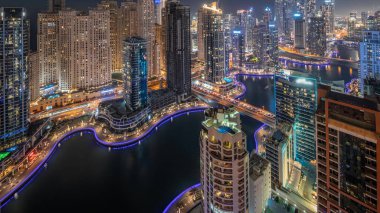 Dubai Marina ve JBR bölgesindeki çeşitli gökdelenlerin görüntüsü suni kanalla gündüz-gece geçişi. Gün batımından sonra birçok kule ve yat