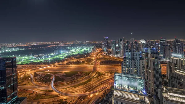 展现媒体城市 迪拜码头和Jlt的全景 用巨大的交叉口空中夜间照亮了谢赫扎耶德路沿线的摩天大楼 月亮升起在住宅 写字楼和高尔夫球场之上 — 图库照片