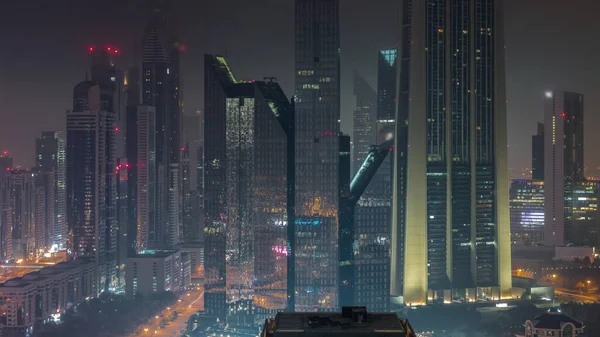 迪拜金融中心附近的摩天大楼高耸入云 通宵灯火通明 沿着繁忙的公路从空中俯瞰塔楼 — 图库照片