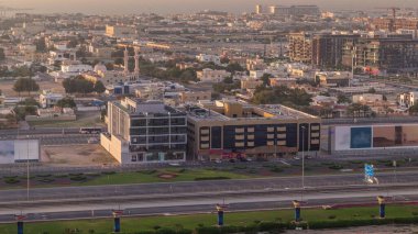 Hava görüntüsünden Dubai Şehir Yürüyüşü 'ne. Düşük katlı binalar ve villaları Avrupa tarzı caddeler olarak yaratılan yeni modern bölüm. Akşam olmadan Şeyh Zayed yolunda trafik vardı.