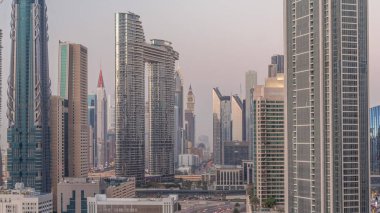Günbatımından sonra Dubai şehir merkezinde ve finans bölgesinde caddelerde trafik olan fütürist kuleler ve gökdelenler. Şehir silueti gökyüzü günden geceye geçiş zamanı yukarıdan