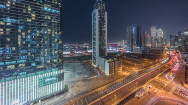 Geleceğin kuleleri ve aydınlanmış gökdelenleri Dubai şehir merkezi ve finans bölgesinde trafiği olan panorama. Urban City Ufuk Çizgisi Hava Gecesi Zaman Çizgisi. Villalar ve şeyh zayed yolu.