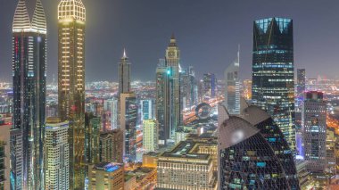 Dubai 'deki Sheikh Zayed Yolu' ndaki parlayan yüksek binaların gökyüzü manzarası. Uluslararası Finans Merkezi 'nde yukarıdan aydınlatılmış gökdelenler