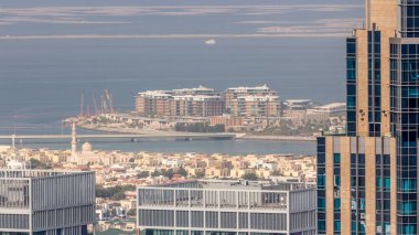 Şehir merkezindeki Dubai şehrindeki apartman ve villaların hava manzarası. Camili gökdelenin arkasına bak. Arka planda yapay adalar. Birleşik Arap Emirlikleri