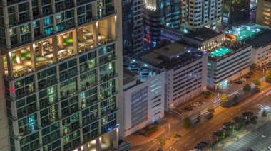 Dubai havaalanındaki yoğun yol yakınındaki çok katlı otoparkın tepesindeki çatı yüzme havuzu, BAE. Yukarıdan ve parlayan pencerelerden Uluslararası Finans Merkezi 'nde kuleler