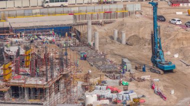 Çalışan vinçleri olan büyük bir inşaat alanı. Business Bay, Dubai 'deki büyük yerleşim ve ofis alanının en iyi hava görüntüsü. Yığınlı kazı çukuru