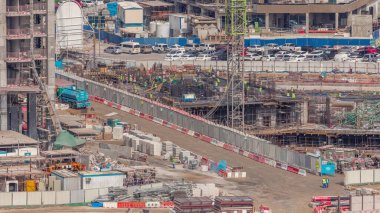 Çalışan vinçleri olan büyük bir inşaat alanı. Takviye yapan işçiler. Business Bay, Dubai 'deki büyük yerleşim ve ofis alanının en iyi hava manzarası