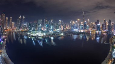Dubai Business Bay ve Downtown 'ın tüm gece boyunca çeşitli gökdelenleri ve kuleleri olan hava panoraması kanal gece zaman çizelgesi boyunca uzanır. Vinçleri sis kaplı inşaat alanı