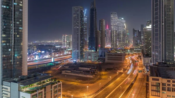 迪拜下城和金融区街道上的未来塔和照明摩天大楼从上往下 城市天际线空中夜间飞逝 — 图库照片