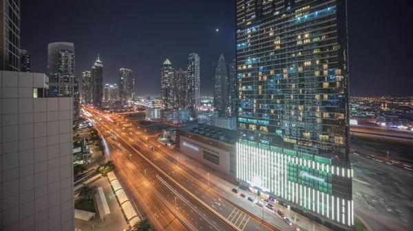 商湾区的天际线与现代建筑和设置月亮时间的夜晚从上方 迪拜的摩天大楼和主干道附近的照明塔的空中全景 十字路口的交通 — 图库照片