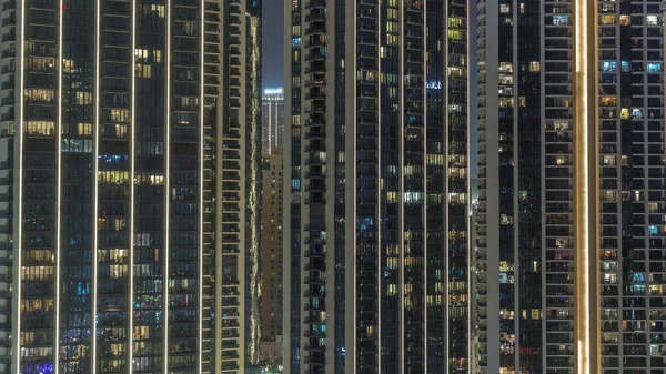 城市空中飞行时间居民区的高楼有发光的窗户 塔楼和照明摩天大楼公寓房间的夜光 — 图库照片