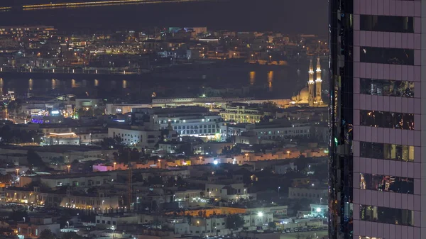 ドバイ市内のアパートやヴィラの空中ビューダウンタウンの夜のタイムラプス近く 超高層ビルの後ろに照らされたモスク アラブ首長国連邦 — ストック写真