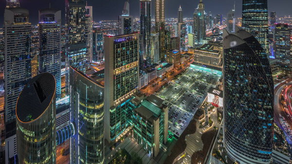 Skyline view of the high-rise buildings on Sheikh Zayed Road in Dubai aerial night timelapse, UAE. Illuminated skyscrapers in International Financial Centre from above. Parking near shopping avenue