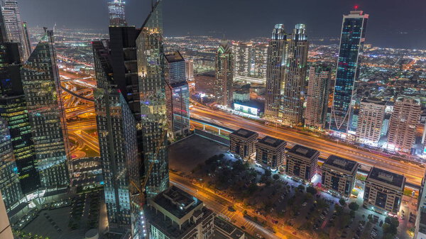High-rise buildings on Sheikh Zayed Road in Dubai aerial night timelapse, UAE. Skyscrapers in international financial district panoramic view from above. City walk houses and villas on a background