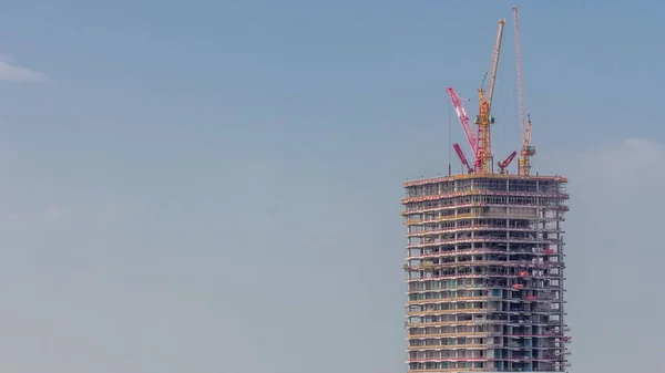 许多塔式起重机在新摩天大楼的建筑工地上工作 该大楼为商业高层大厦的空中定时器 迪拜市中心的建筑进展 蓝天背景 — 图库照片